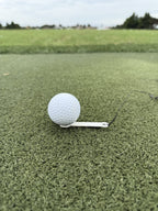 Close-up of a golf ball on The Perfect Divot tee on a hitting mat